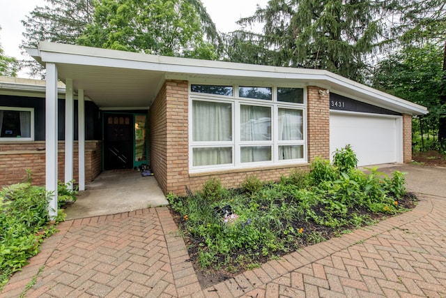 3431 Pineview Dr, Dexter, MI 48130 - view of front facade featuring brick siding, driveway, and a garage