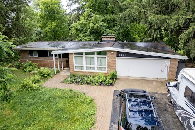 3431 Pineview Dr, Dexter, MI 48130 - view of front of home featuring brick siding, a chimney, and a garage