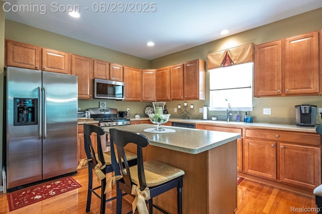 601 Acadia Ct, Howell, MI 48843 - kitchen featuring appliances with stainless steel finishes, light wood finished floors, a center island, a kitchen bar, and recessed lighting