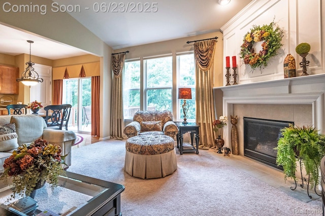601 Acadia Ct, Howell, MI 48843 - living room with light colored carpet, a fireplace with flush hearth, and lofted ceiling