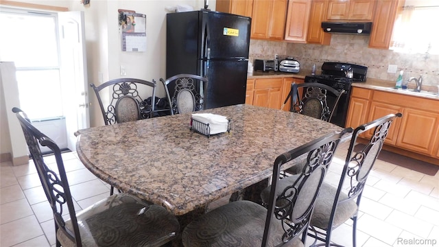 27038 Grobbel Dr, Warren, MI 48092 - kitchen featuring black appliances, ventilation hood, light tile patterned floors, decorative backsplash, and a kitchen bar