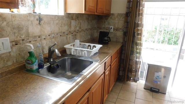 27038 Grobbel Dr, Warren, MI 48092 - kitchen featuring brown cabinetry, decorative backsplash, and light tile patterned floors