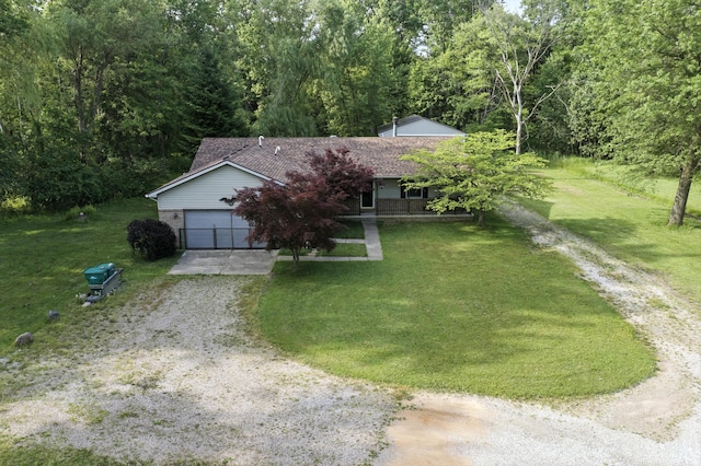 26434 King Rd, Romulus, MI 48174 - view of property hidden behind natural elements featuring driveway, a front yard, a view of trees, and a garage