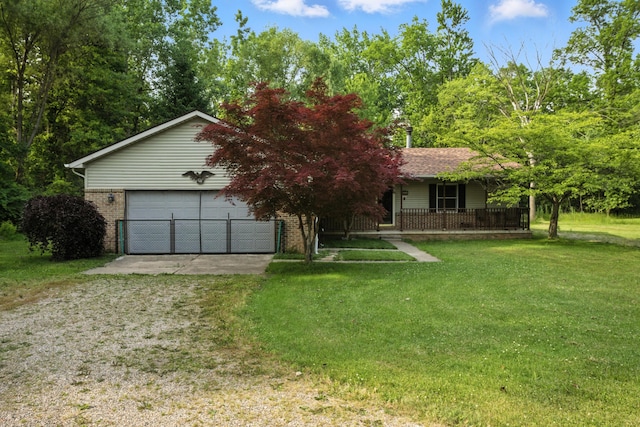 26434 King Rd, Romulus, MI 48174 - view of front of house featuring brick siding, a porch, driveway, and a detached garage