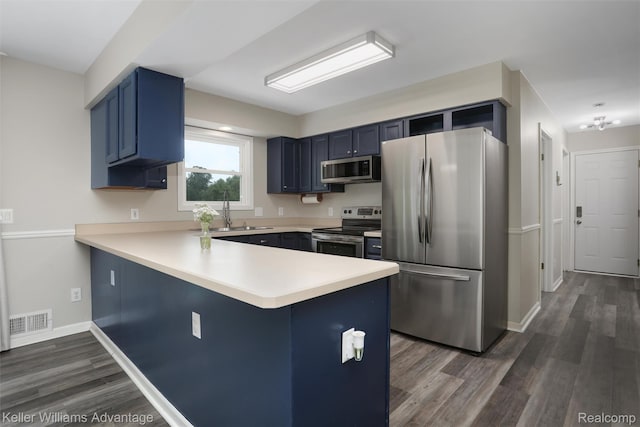 26855 King Rd, Brownstown, MI 48174 - kitchen with stainless steel appliances, blue cabinetry, a peninsula, and light countertops