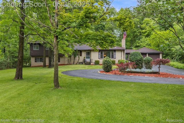29866 Woodland Dr, Southfield, MI 48034 - view of front of home featuring driveway, a front yard, a chimney, and an attached garage