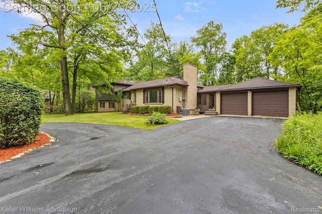 29866 Woodland Dr, Southfield, MI 48034 - tri-level home featuring driveway, an attached garage, a chimney, and a front yard