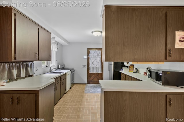 29866 Woodland Dr, Southfield, MI 48034 - kitchen with stainless steel appliances, light countertops, brick patterned floors, and a peninsula