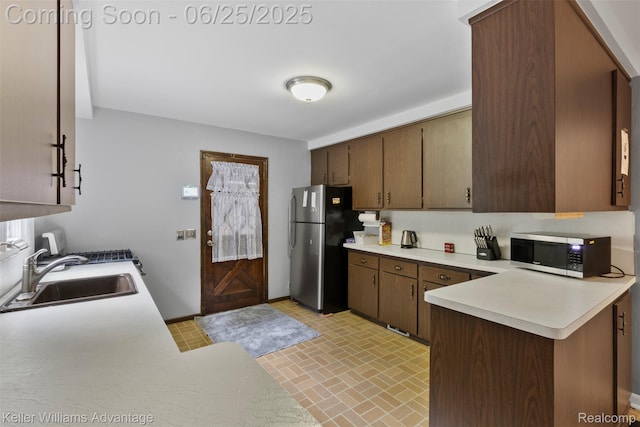 29866 Woodland Dr, Southfield, MI 48034 - kitchen featuring stainless steel appliances, light countertops, brick patterned flooring, and a peninsula