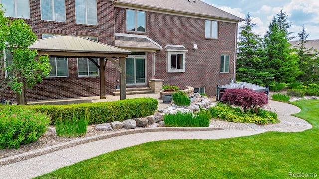 56343 Via Serbelloni, Macomb, MI 48042 - rear view of house featuring a gazebo, brick siding, and a yard