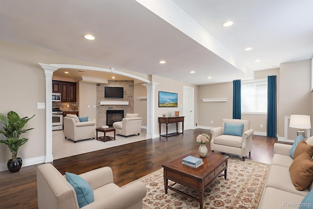 56343 Via Serbelloni, Macomb, MI 48042 - living area featuring ornate columns, light wood-type flooring, a fireplace, and recessed lighting