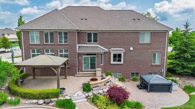 56343 Via Serbelloni, Macomb, MI 48042 - back of property featuring a gazebo, a patio, a hot tub, a shingled roof, and brick siding