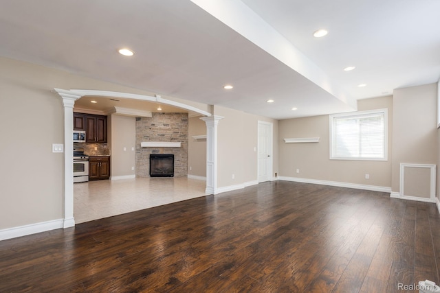 56343 Via Serbelloni, Macomb, MI 48042 - unfurnished living room featuring ornate columns, wood-type flooring, a fireplace, and recessed lighting