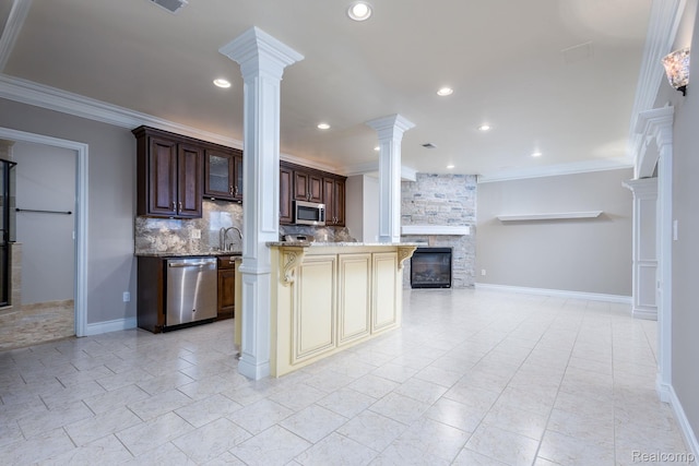 56343 Via Serbelloni, Macomb, MI 48042 - kitchen with stainless steel appliances, decorative columns, a stone fireplace, open floor plan, and a breakfast bar
