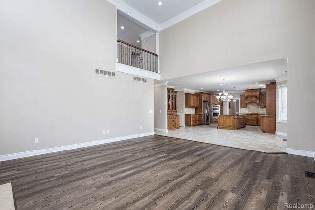 56343 Via Serbelloni, Macomb, MI 48042 - unfurnished living room featuring a chandelier, wood finished floors, recessed lighting, crown molding, and a high ceiling