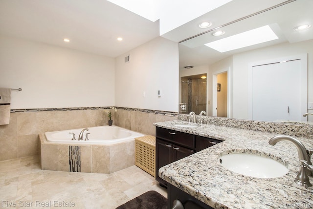 7025 Dandison Blvd, West Bloomfield, MI 48324 - full bath featuring double vanity, recessed lighting, a garden tub, a skylight, and a stall shower