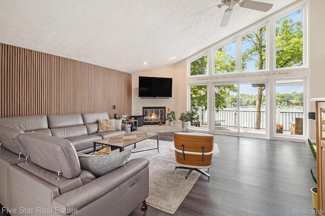 7025 Dandison Blvd, West Bloomfield, MI 48324 - living area featuring a ceiling fan, a tiled fireplace, high vaulted ceiling, plenty of natural light, and dark wood-style floors