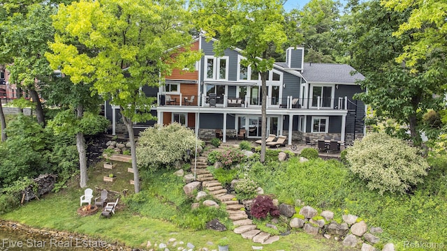 7025 Dandison Blvd, West Bloomfield, MI 48324 - back of property featuring stairway, a patio area, a chimney, stone siding, and a wooden deck