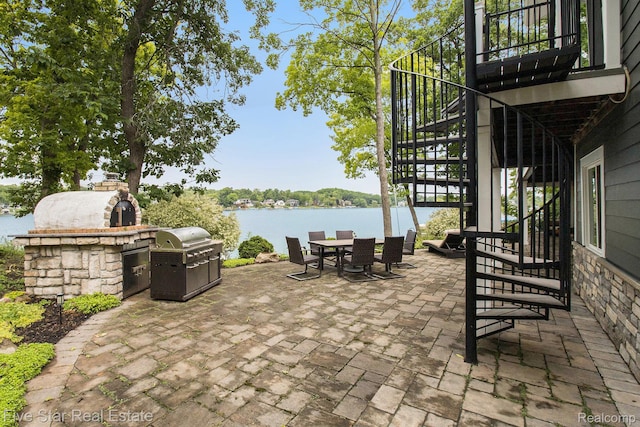 7025 Dandison Blvd, West Bloomfield, MI 48324 - view of patio featuring stairway, outdoor dining space, a water view, and area for grilling