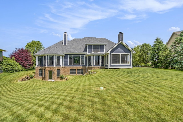 6577 Heron Ct, Ann Arbor, MI 48103 - rear view of house with a chimney, a lawn, and brick siding