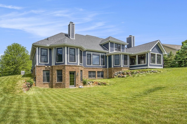 6577 Heron Ct, Ann Arbor, MI 48103 - back of house with a chimney, a sunroom, a yard, and brick siding