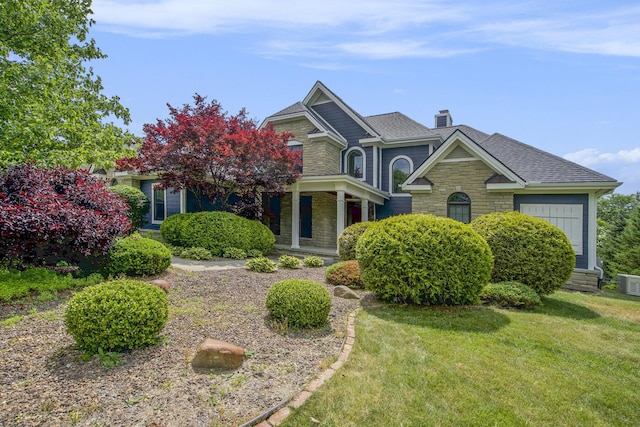 6577 Heron Ct, Ann Arbor, MI 48103 - view of front of home featuring a chimney, stone siding, a front yard, and roof with shingles