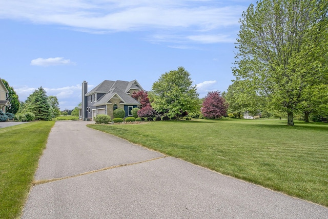 6577 Heron Ct, Ann Arbor, MI 48103 - view of front of property featuring driveway, a front lawn, an attached garage, and a chimney