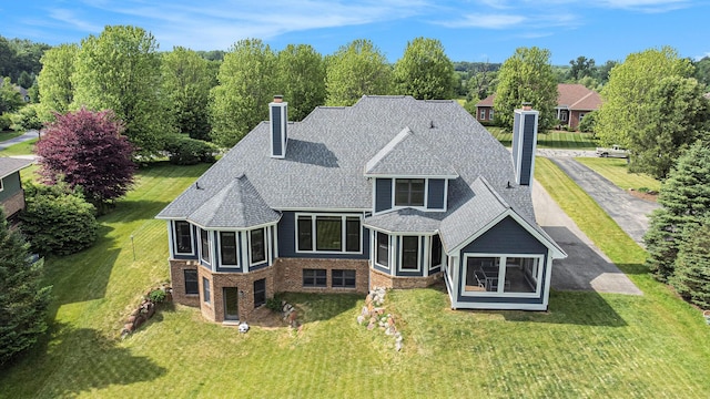 6577 Heron Ct, Ann Arbor, MI 48103 - rear view of property featuring a chimney, a sunroom, and a shingled roof