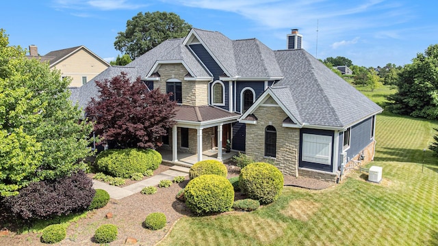 6577 Heron Ct, Ann Arbor, MI 48103 - view of front of house featuring stone siding, a chimney, covered porch, and a front yard