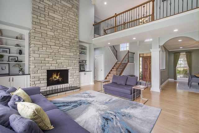 6577 Heron Ct, Ann Arbor, MI 48103 - living area featuring a high ceiling, arched walkways, built in shelves, wood finished floors, and a stone fireplace