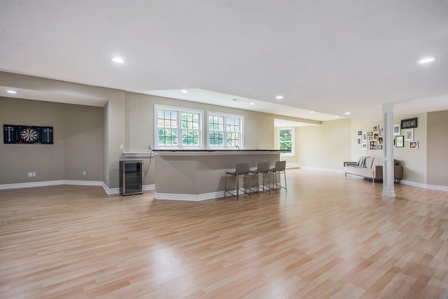 6577 Heron Ct, Ann Arbor, MI 48103 - living room with wine cooler, healthy amount of natural light, decorative columns, light wood-type flooring, and recessed lighting