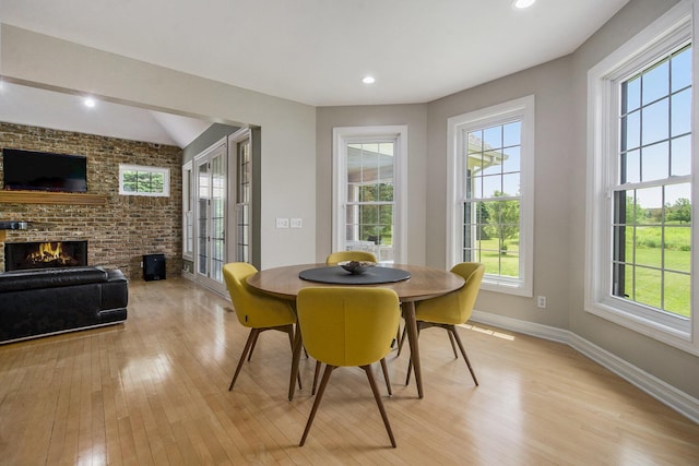 6577 Heron Ct, Ann Arbor, MI 48103 - dining room with light wood finished floors, a fireplace, brick wall, and recessed lighting