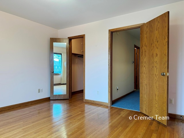 4074 Grandview Ter SW, Grandville, MI 49418 - unfurnished bedroom featuring wood finished floors, a spacious closet, and a closet