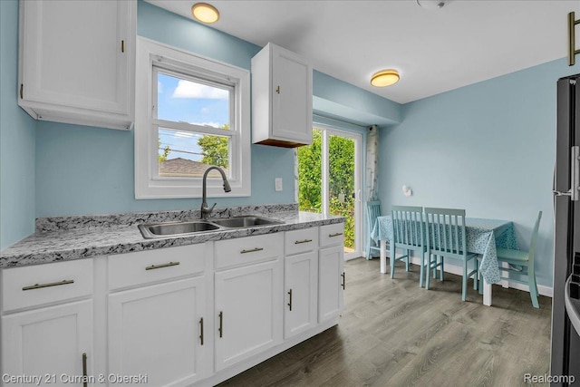 1678 Merrill Ave, Lincoln Park, MI 48146 - kitchen with white cabinetry, wood finished floors, and light stone counters
