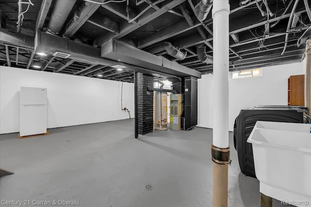 1678 Merrill Ave, Lincoln Park, MI 48146 - basement featuring freestanding refrigerator, heating unit, water heater, and washer and clothes dryer