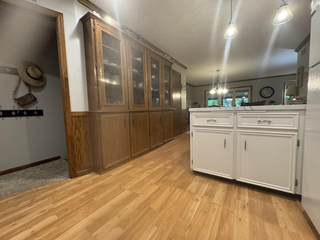 7337 Pine Grove Dr, Jenison, MI 49428 - kitchen with light wood-style floors, a peninsula, glass insert cabinets, and decorative light fixtures