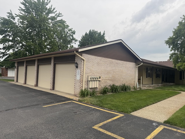 7337 Pine Grove Dr, Jenison, MI 49428 - view of side of home with community garages, a lawn, and brick siding