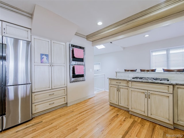 7660 Barnsbury Dr, West Bloomfield, MI 48324 - kitchen featuring stainless steel appliances, light wood-style floors, recessed lighting, light stone countertops, and a skylight