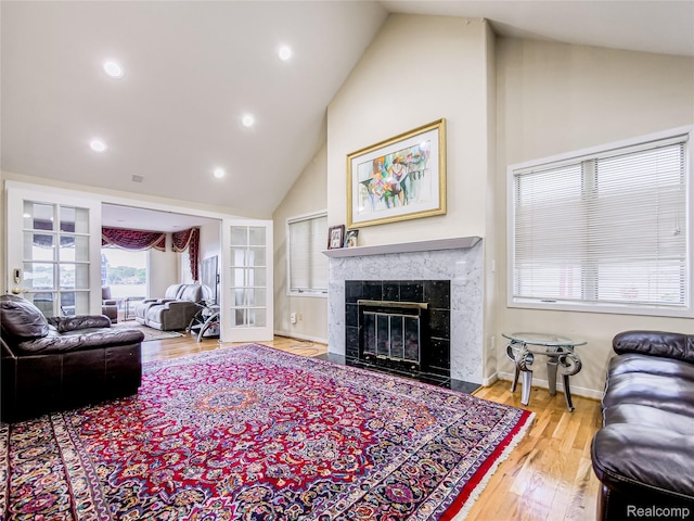7660 Barnsbury Dr, West Bloomfield, MI 48324 - living area featuring high vaulted ceiling, wood finished floors, a tiled fireplace, and recessed lighting