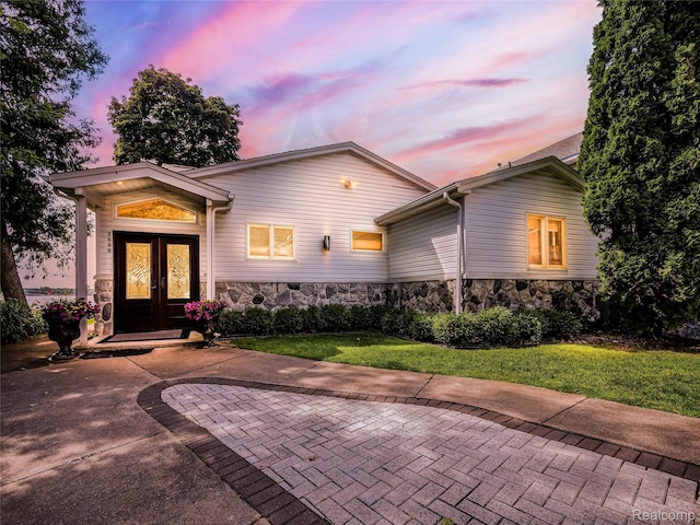 7660 Barnsbury Dr, West Bloomfield, MI 48324 - view of front of house with french doors, stone siding, and a front lawn