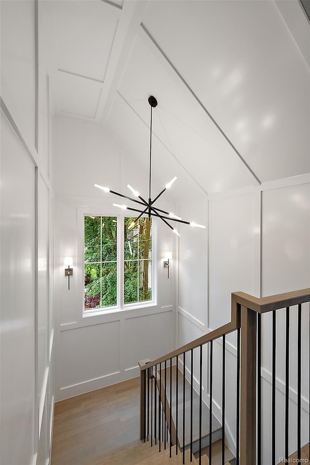 345 Kimberly St, Birmingham, MI 48009 - stairway featuring wood finished floors, a decorative wall, a chandelier, and vaulted ceiling