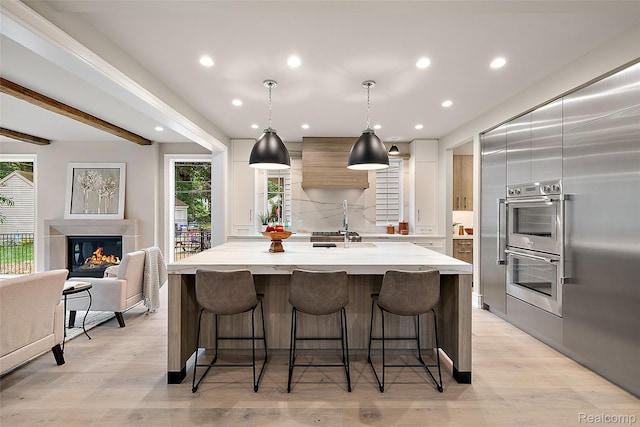 345 Kimberly St, Birmingham, MI 48009 - kitchen with custom range hood, modern cabinets, double oven, a breakfast bar area, and recessed lighting