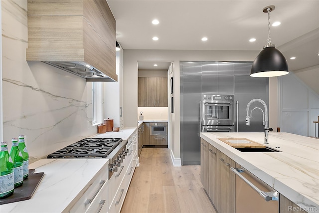 345 Kimberly St, Birmingham, MI 48009 - kitchen with stainless steel appliances, custom exhaust hood, modern cabinets, light wood-type flooring, and light stone countertops