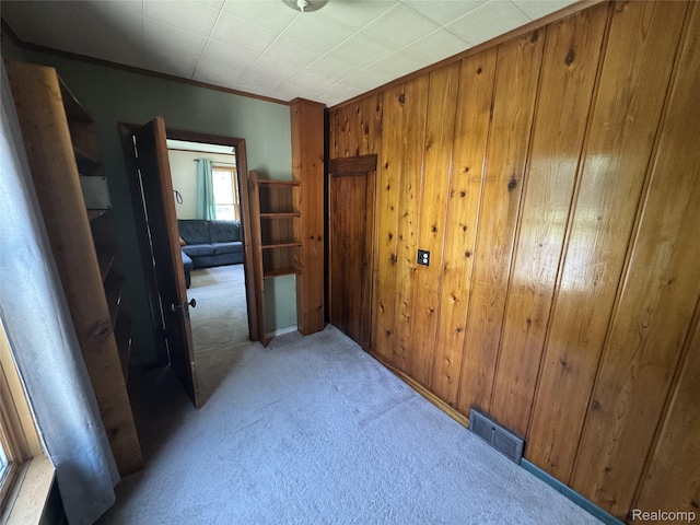 6351 Zimmer Rd, Haslett, MI 48840 - hallway featuring light colored carpet, wood walls, and crown molding