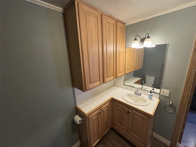 6351 Zimmer Rd, Haslett, MI 48840 - bathroom with ornamental molding, vanity, tasteful backsplash, and wood finished floors