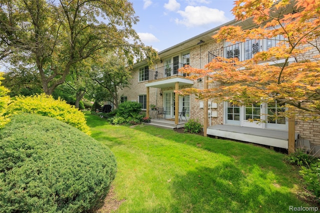 42309 Woodward Ave Unit S1-7, Bloomfield Hills, MI 48304 - rear view of property featuring a balcony, brick siding, and a lawn