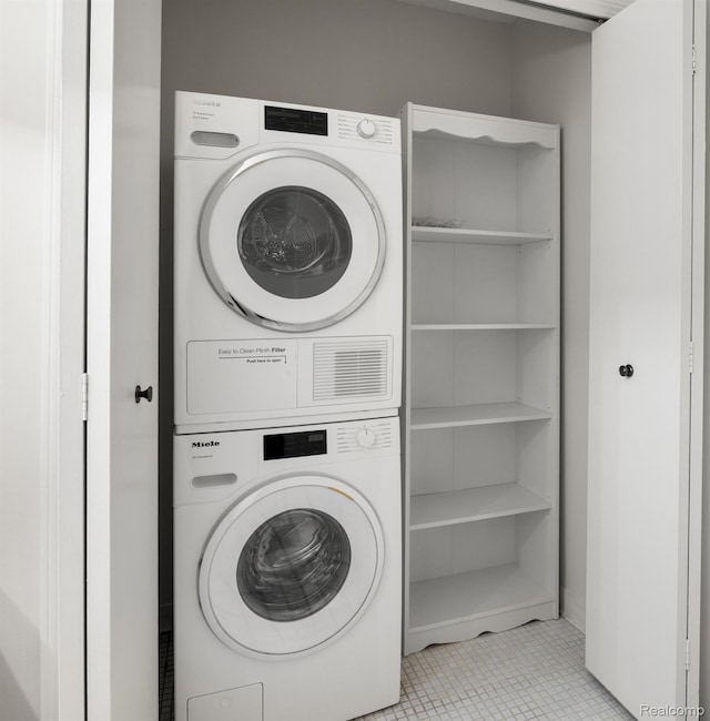 42309 Woodward Ave Unit S1-7, Bloomfield Hills, MI 48304 - washroom featuring stacked washing machine and dryer and tile patterned flooring