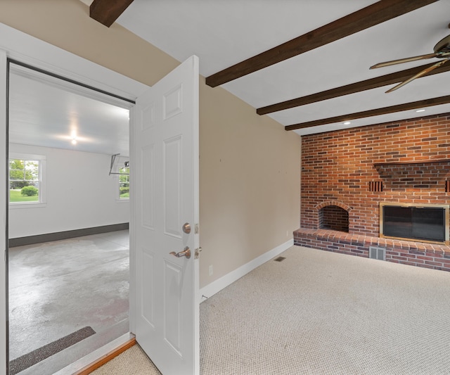 4641 Wylie Rd, Dexter, MI 48130 - unfurnished living room with a fireplace, beam ceiling, a ceiling fan, and carpet floors