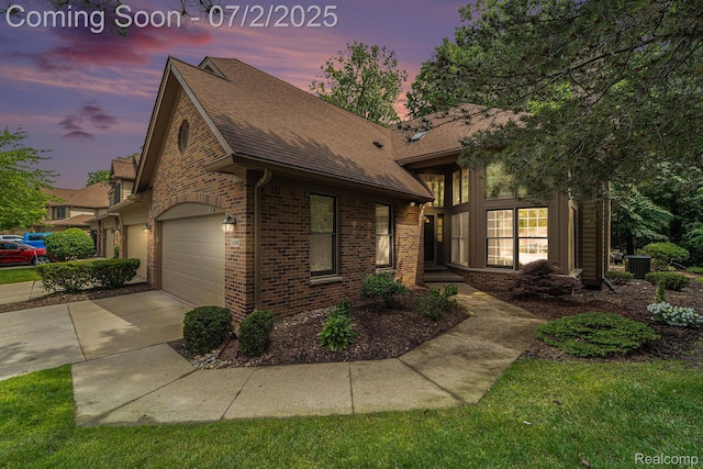 5200 Royal Vale Ln, Dearborn, MI 48126 - view of front facade featuring brick siding, a shingled roof, concrete driveway, and a garage