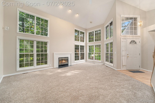5200 Royal Vale Ln, Dearborn, MI 48126 - unfurnished living room featuring high vaulted ceiling, a chandelier, a fireplace with flush hearth, and carpet flooring